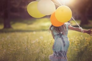Une petite fille qui joue avec des ballons, insouciante